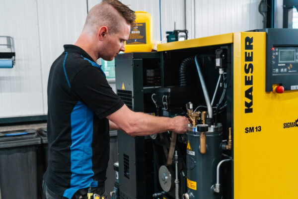 Een monteur die compressor onderhoud of een reparatie uitvoert